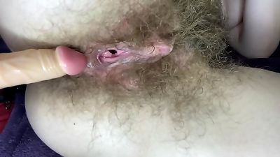 hairy doll pokes her moist huge clit snatch with dildo in close up
